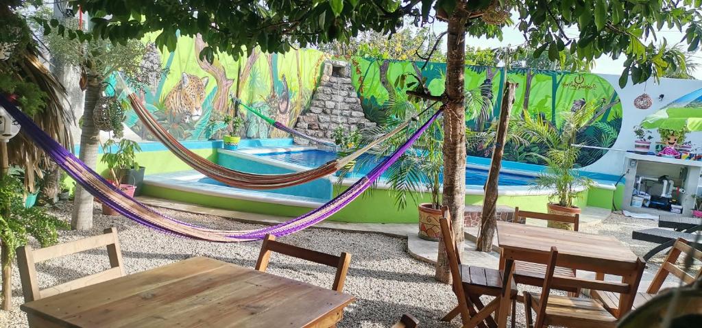 a group of hammocks in a room with a painting at Zayali Bacalar - Guest House in Bacalar