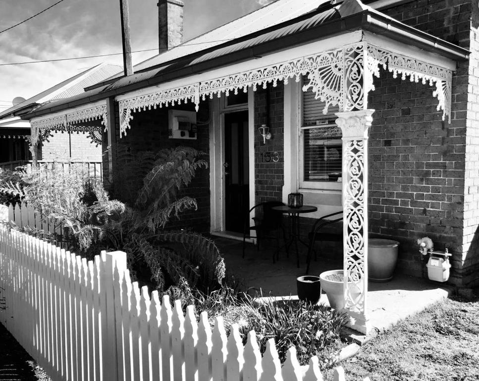 una cerca blanca frente a una casa en The Edward Townhouses 151 & 153, en Orange