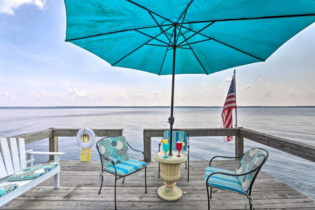 uma mesa e cadeiras numa doca com um guarda-sol em Idyllic Waterfront Escape with Private Boat Dock! em Santee