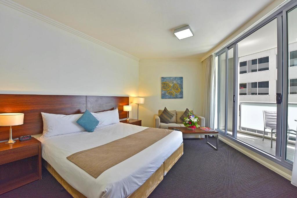 a hotel room with a large bed and a large window at APX World Square in Sydney