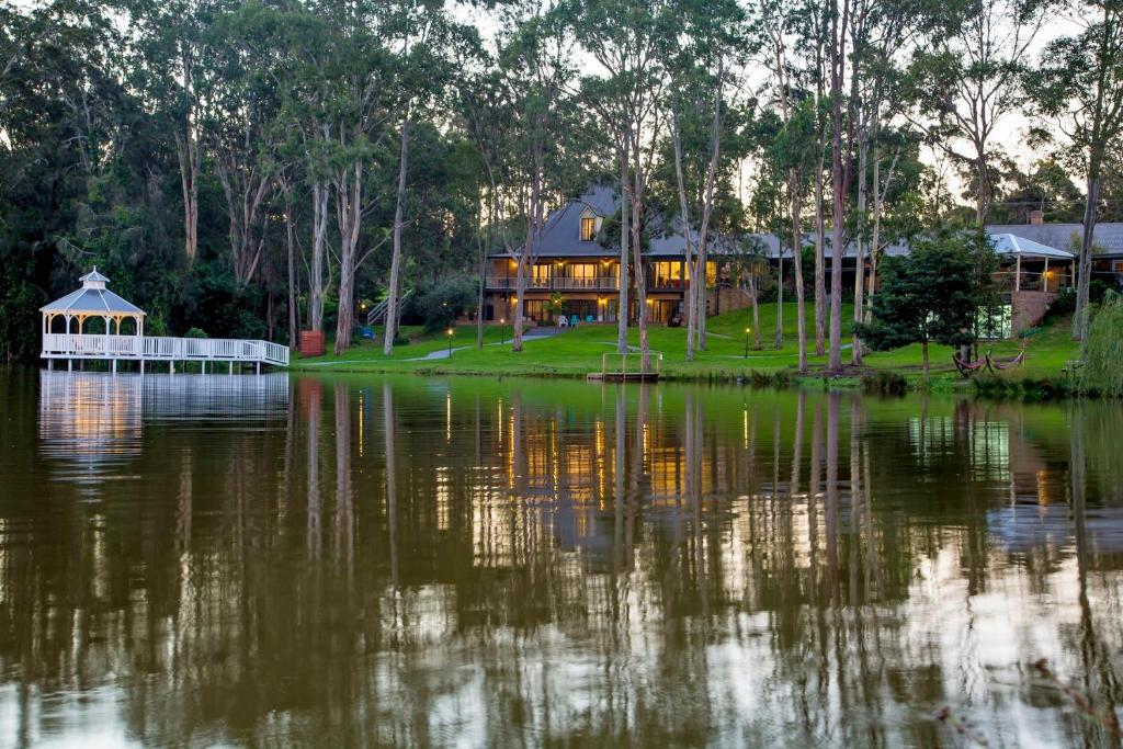 Lincoln Downs Resort Batemans Bay في خليج بايتمانس: منزل كبير على شاطئ البحيرة