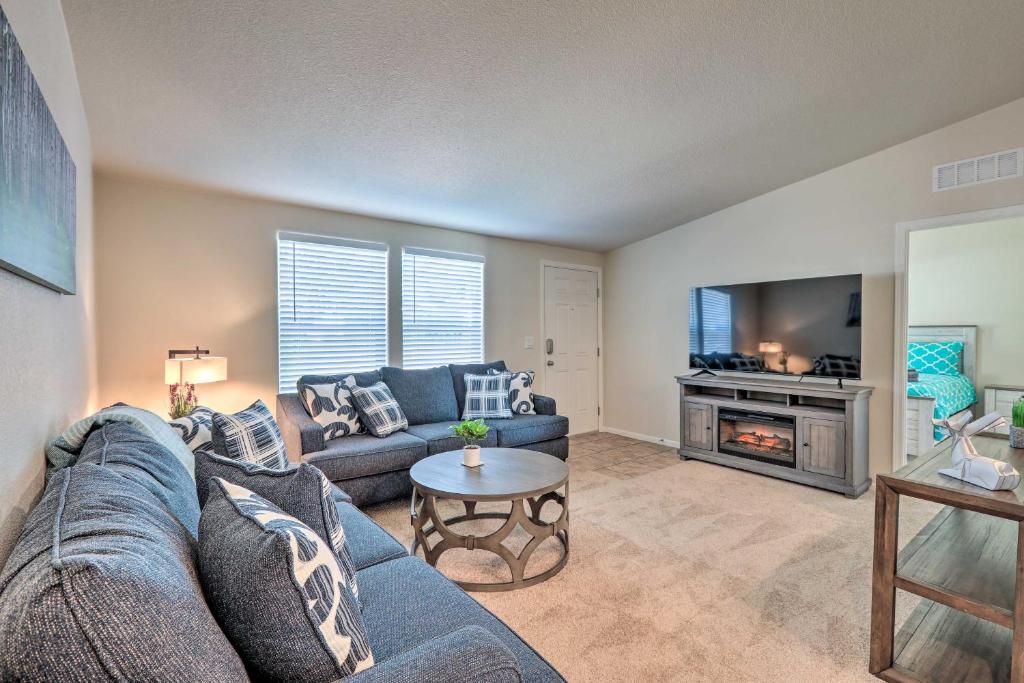 a living room with a blue couch and a tv at Bright and Modern Flagstaff Cottage Escape! in Mountainaire