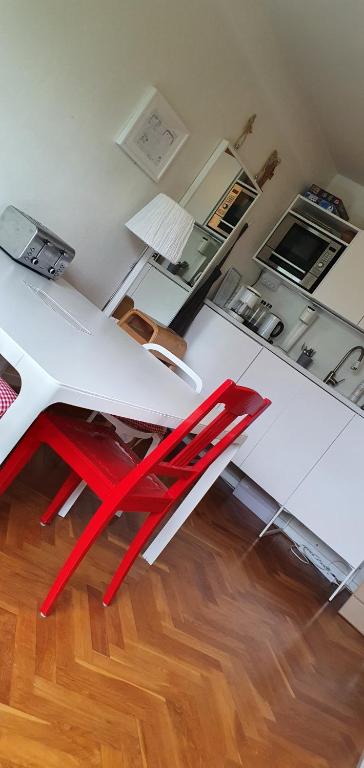 una silla roja sentada sobre una mesa blanca en Cityclose for five Malmö, en Malmö