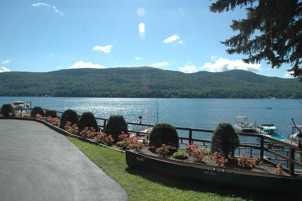 a view of a lake with a fence and flowers at Park Lane Motel in Lake George