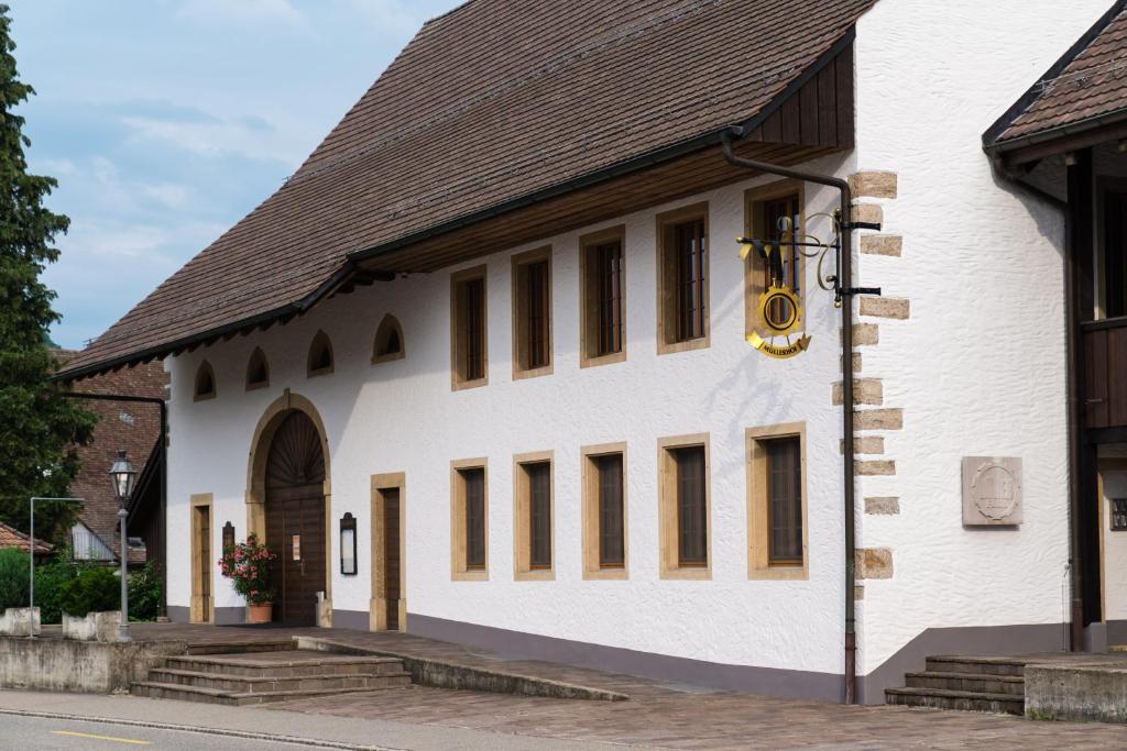 a large white building with a brown roof at Hotel Müllerhof in Frick