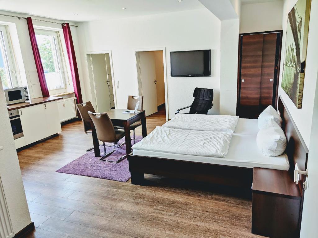Boardinghouse - Stadtvilla Budget في شفاينفورت: غرفة نوم بسرير وطاولة وكراسي