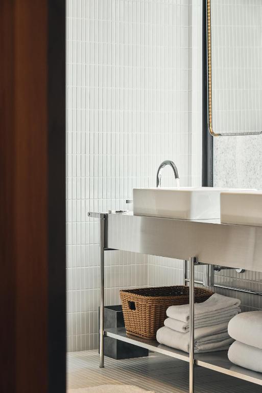 a bathroom with a sink and a basket and towels at Kimpton Da An Taipei- an IHG Hotel in Taipei