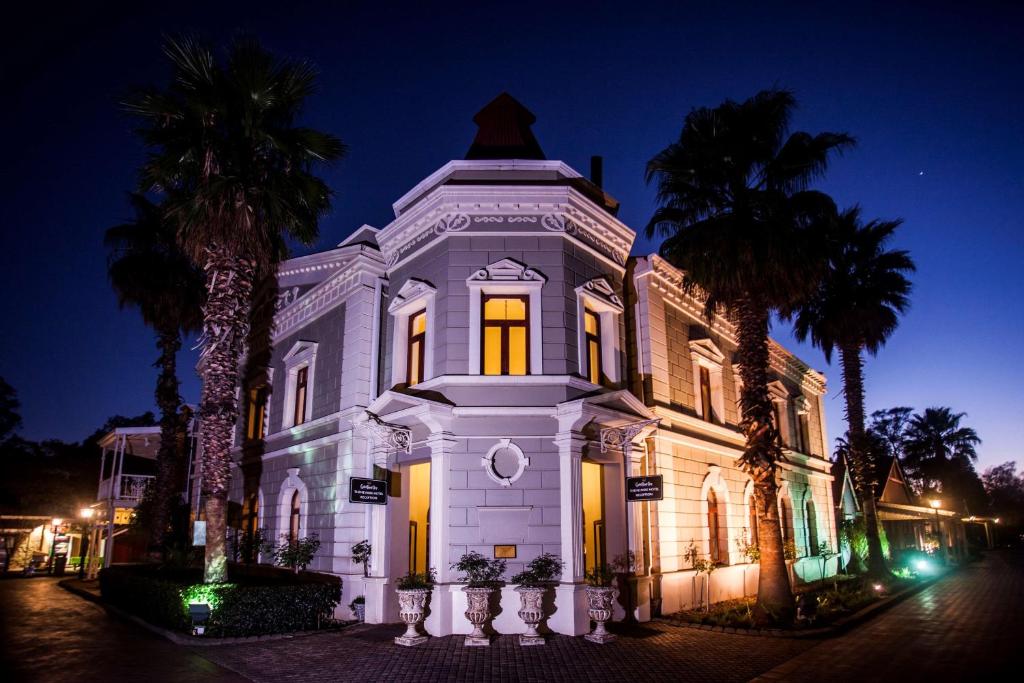 a white building with palm trees in front of it at Gold Reef City Theme Park Hotel in Johannesburg