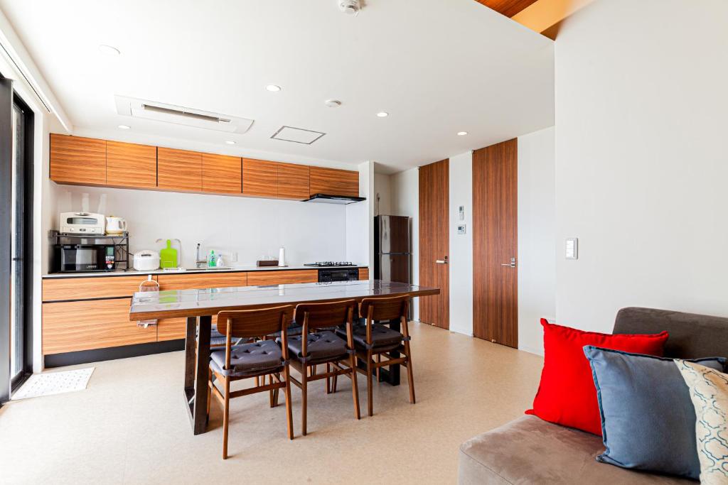 a kitchen and living room with a table and chairs at Onna Beach Square -恩納ビーチスクエア- in Onna