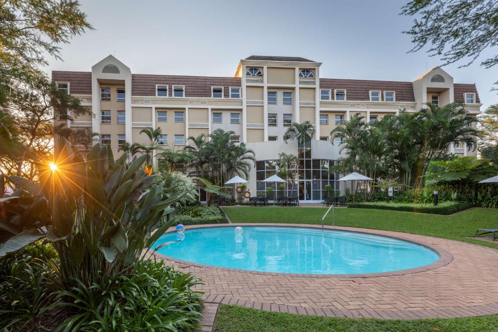 a large building with a swimming pool in front of it at StayEasy Mbombela in Nelspruit