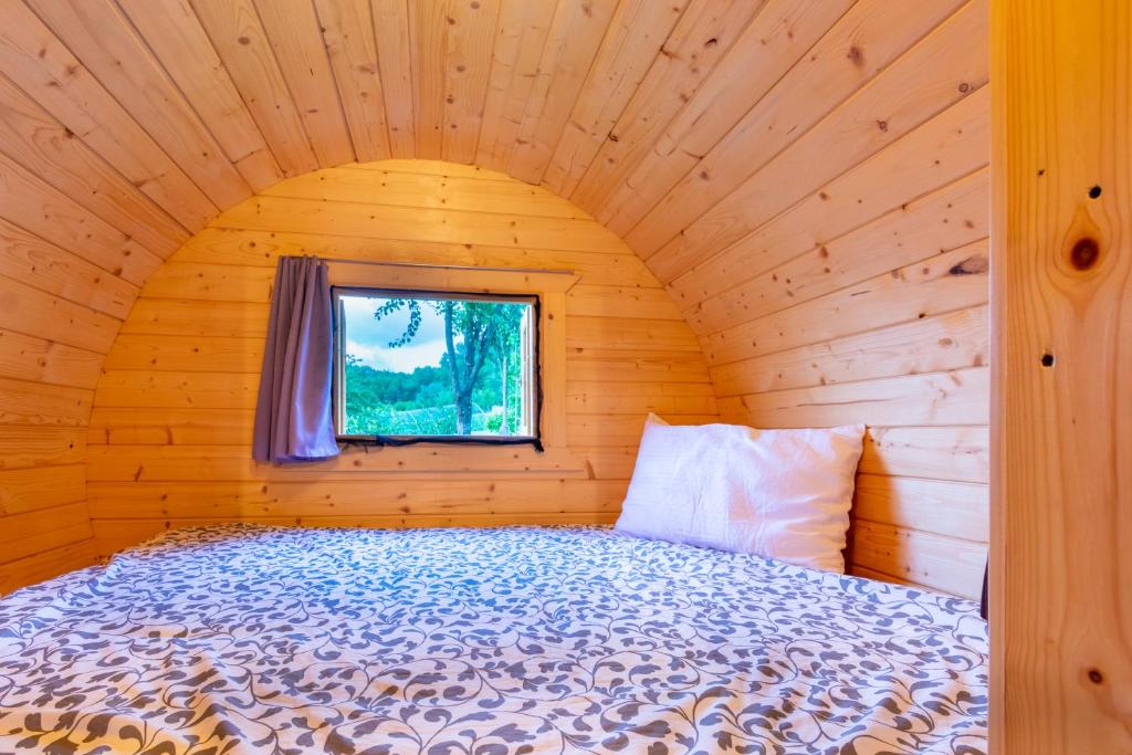 a bed in a wooden room with a window at B&B Cascina Sant'Elena in Bubbio