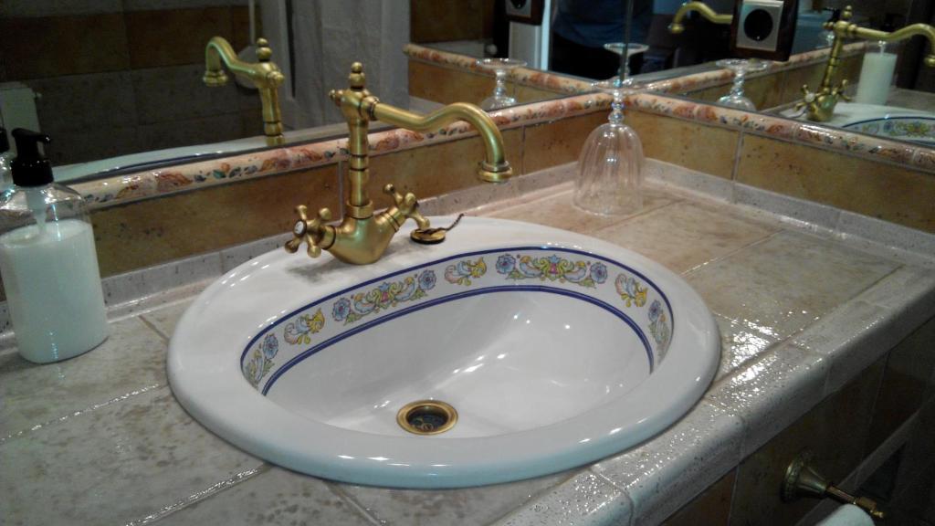 
a sink in a bathroom with a mirror above it at Casa de La Campana in Cieza
