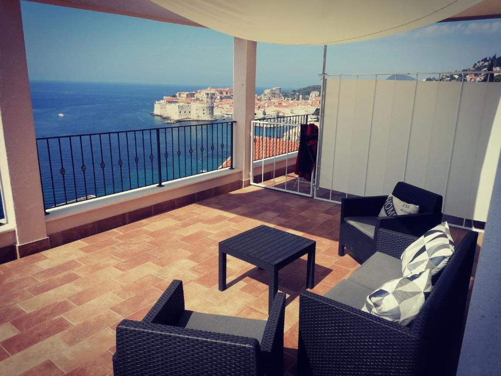 a balcony with chairs and a table and a view of the ocean at Villa Ragusa in Dubrovnik