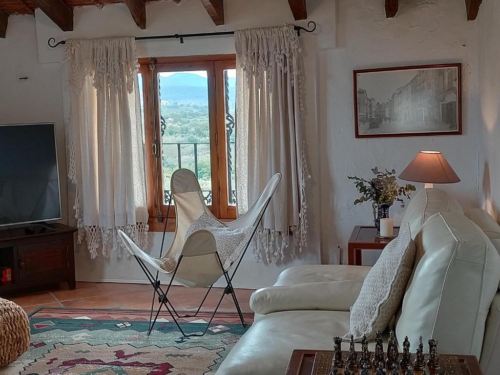 ein Wohnzimmer mit einem Sofa, Stühlen und einem Fenster in der Unterkunft Ca'n Josep in Segorbe