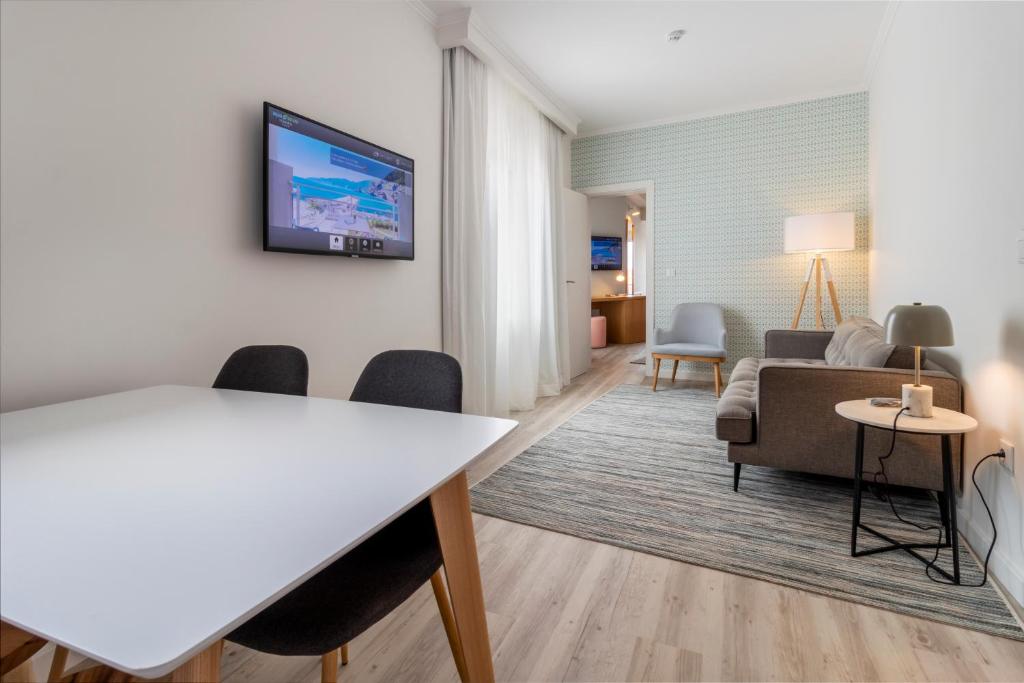 a living room with a couch and a tv on a wall at Aqua Natura Bay in Porto Moniz