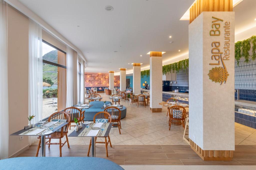 a restaurant with tables and chairs and a bar at Aqua Natura Bay in Porto Moniz