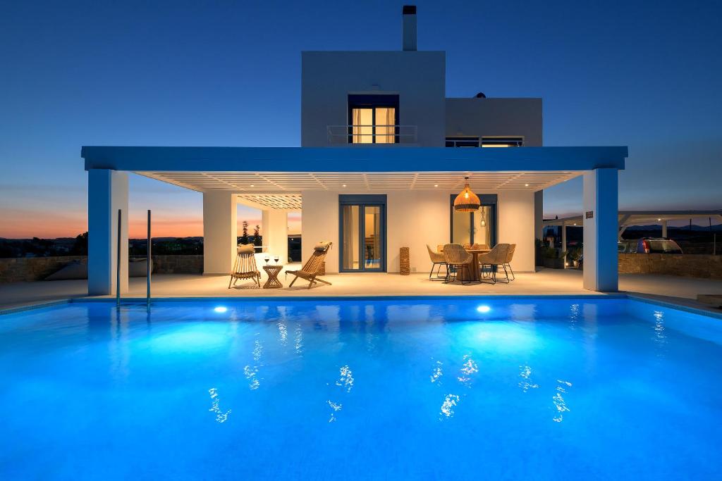 a large blue swimming pool in front of a house at Astrea Villas in Lakhania