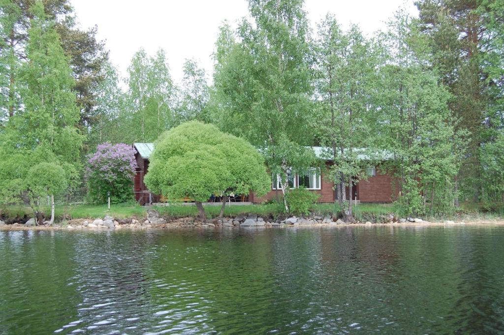 a house on the shore of a body of water at Lomasaaret Cottages in Villala