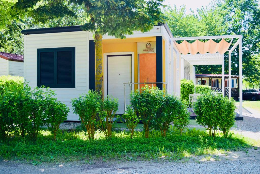 a tiny house with an orange door and a porch at Eco house Roero cottage in Alba