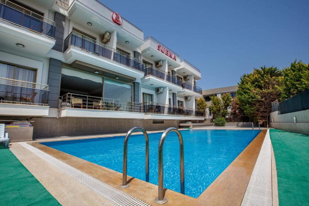 a swimming pool in front of a hotel at Suena hotel Çeşme in Çeşme
