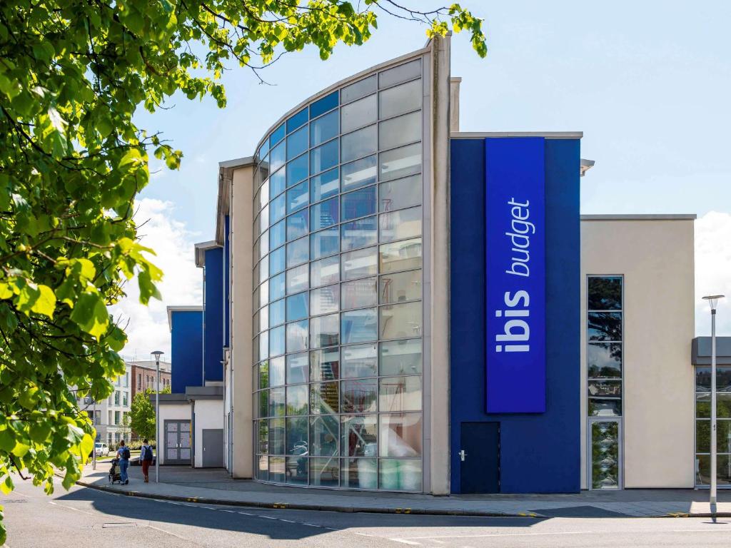 ein Glasgebäude mit einem blauen Schild darauf in der Unterkunft ibis Budget Portishead Marina in Portishead