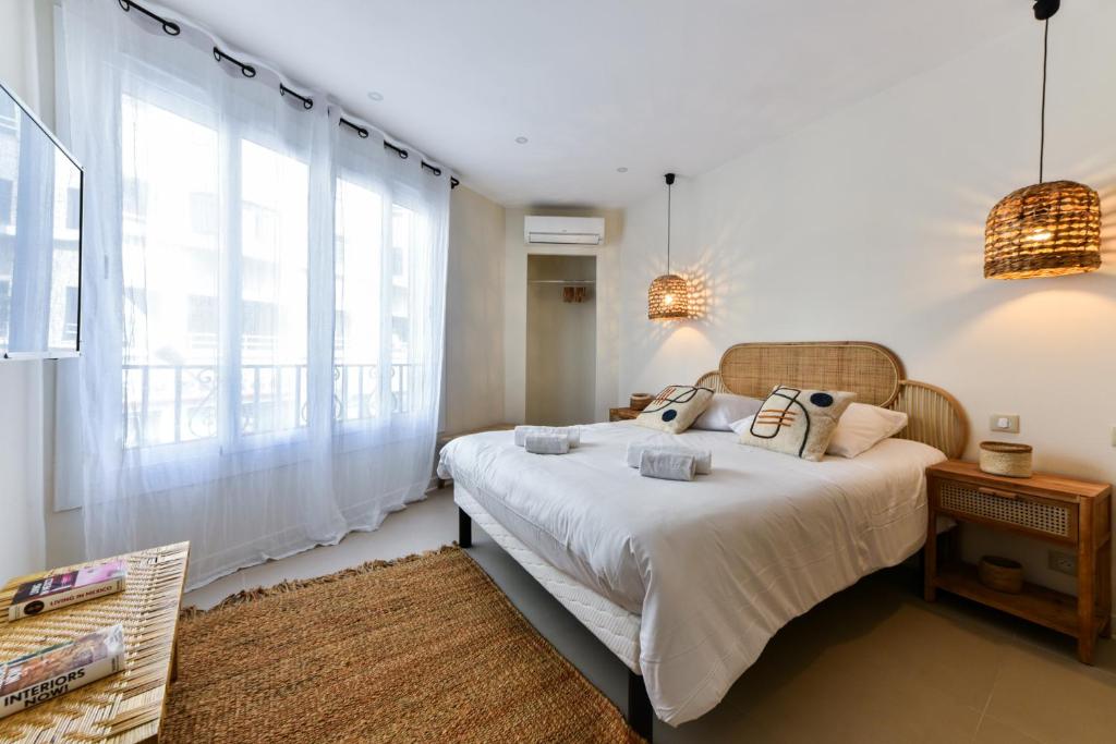 um quarto com uma cama e uma grande janela em CMG Cozy appartement Juan-Les-Pins / 200m Plage em Antibes