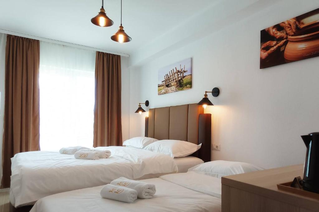 Dos camas en una habitación de hotel con toallas. en Casa Lacul Doamnei en Ocnele Mari