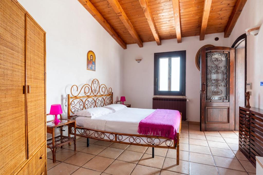 sypialnia z łóżkiem i drewnianym sufitem w obiekcie Villa Melinda - Charme Holidays w mieście Licata