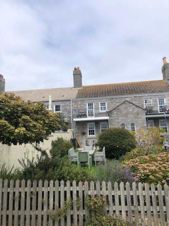 ein Haus mit einem weißen Zaun davor in der Unterkunft Beautiful Sea Front Cottage in the Ocean City in Plymouth