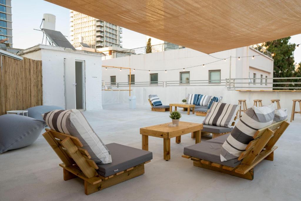 a patio with chairs and tables on a roof at Meir's Boutique Guesthouse in Tel Aviv