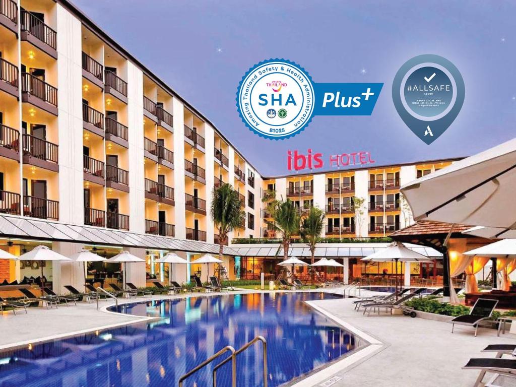 a hotel with a swimming pool in front of a building at Ibis Phuket Kata in Kata Beach