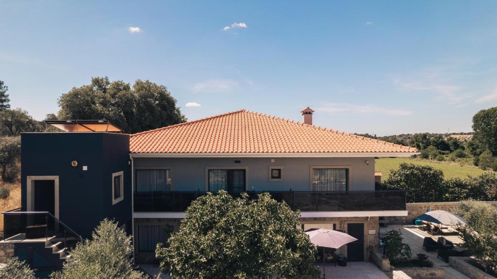 uma casa com um telhado laranja e uma casa em Arca dos Animais - Farming & SPA em Castelo Branco