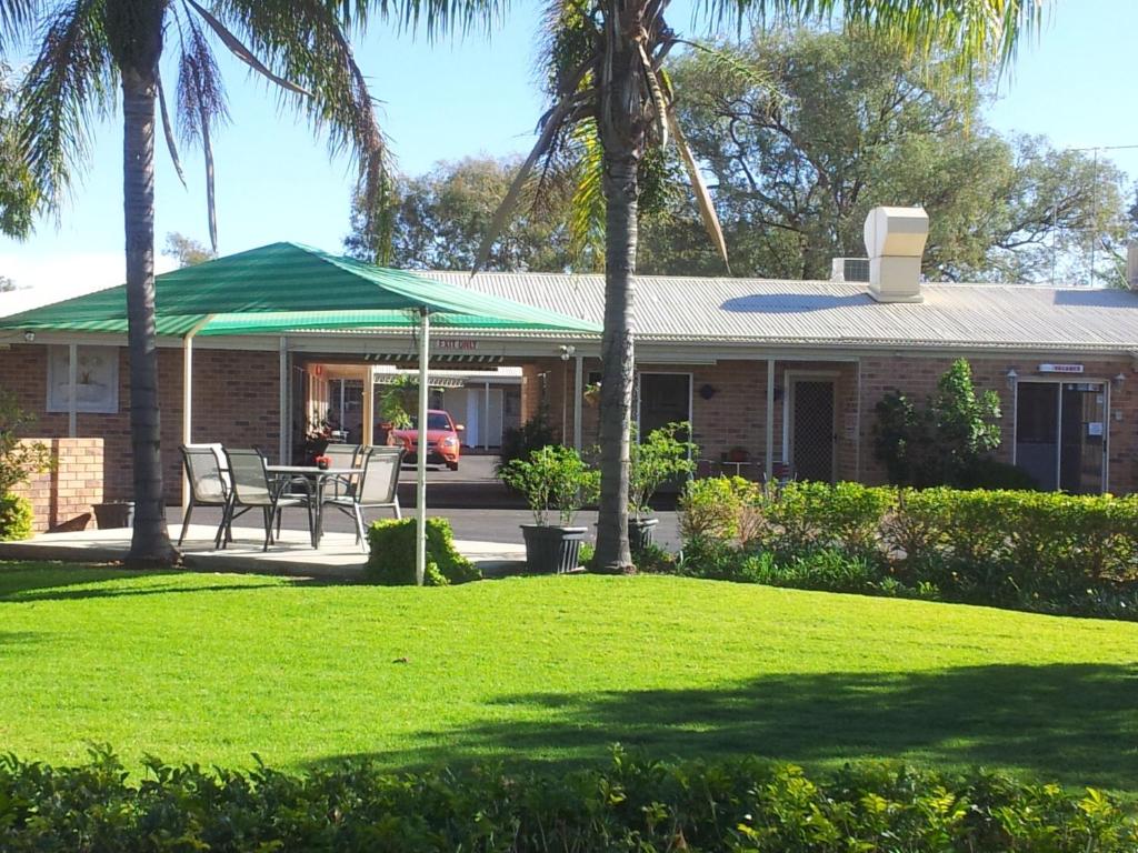 una casa con techo verde y césped en Charleville Waltzing Matilda Motor Inn, en Charleville