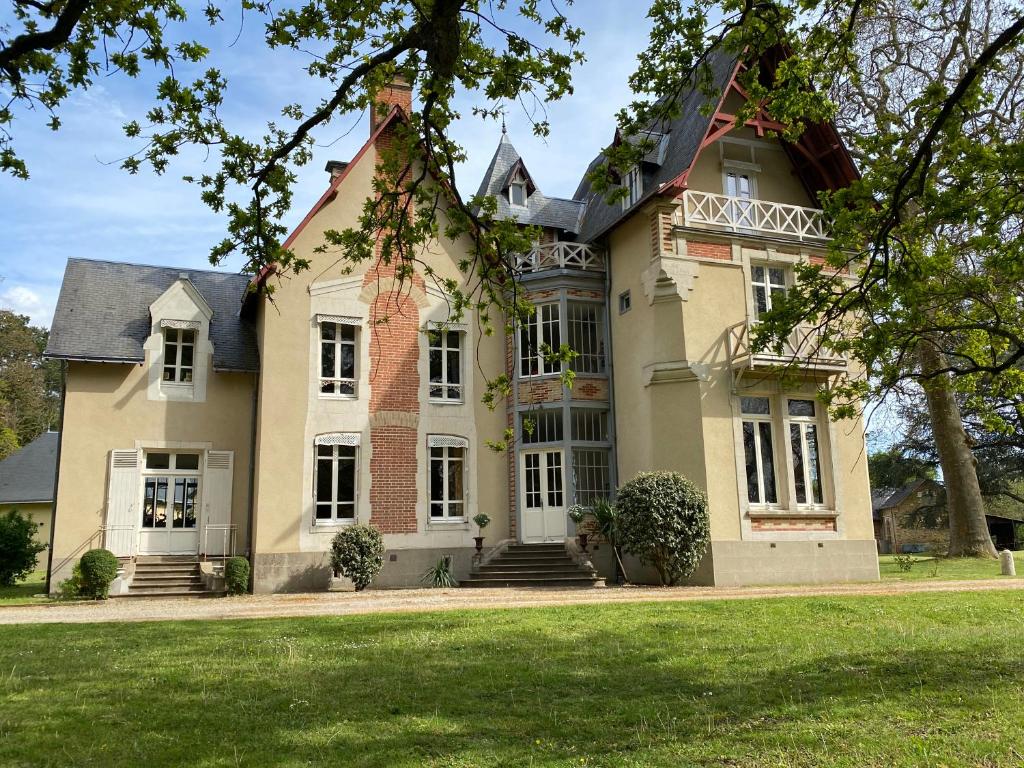 a large house with a large lawn in front of it at Château de la Coudraie in Changé