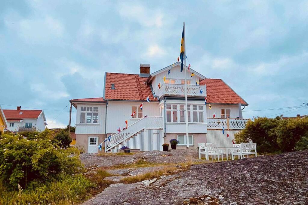 una gran casa blanca con techo rojo en Fin lägenhet i vårt hus med uteplats på Käringön en Käringön