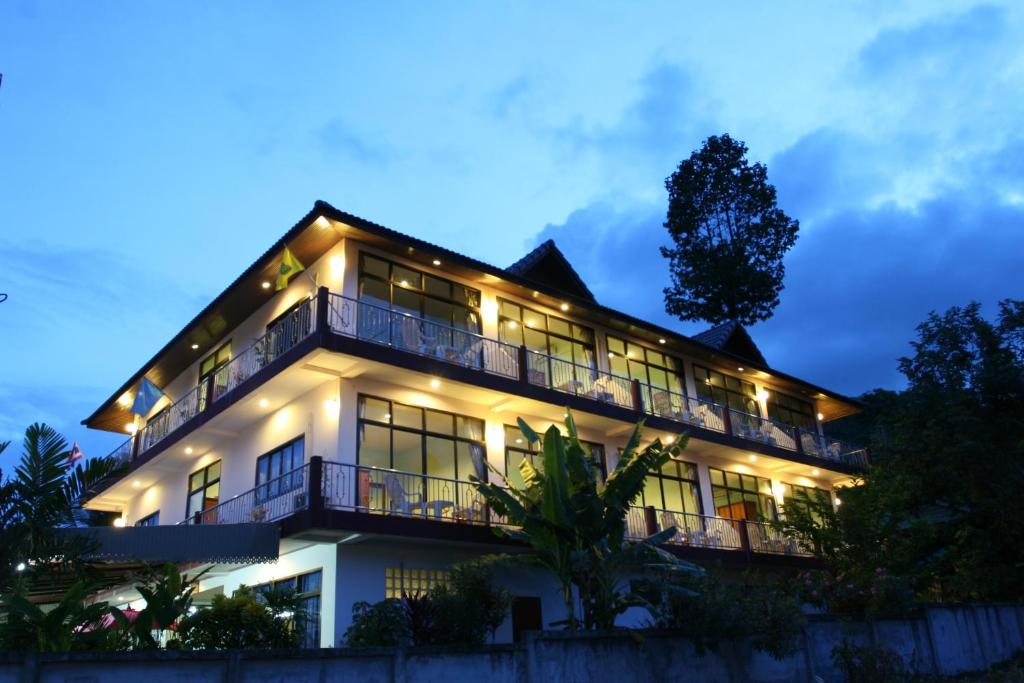 un gran edificio blanco con luces encendidas en BT Mansion, en Lamai