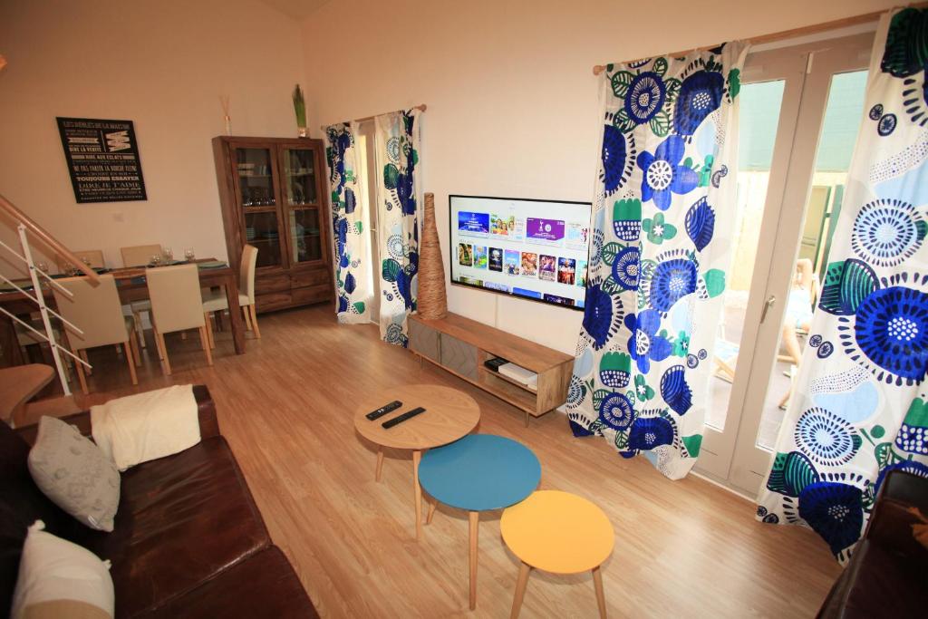 a living room with a couch and a tv at Villa Mama Cocha 8 minutes à pied des plages in Sanary-sur-Mer