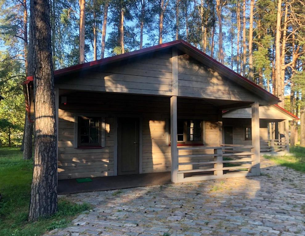 a small wooden cabin in the middle of a forest at Krodziņš Kristapiņš in Babīte