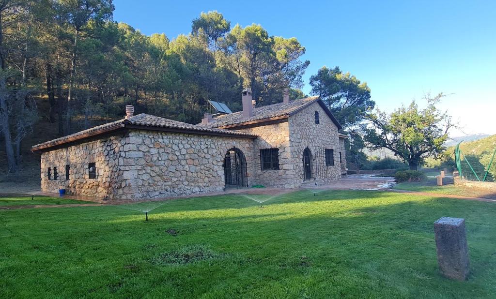 an old stone church in a field with a grass yard at Valdemarin Rural in Orcera