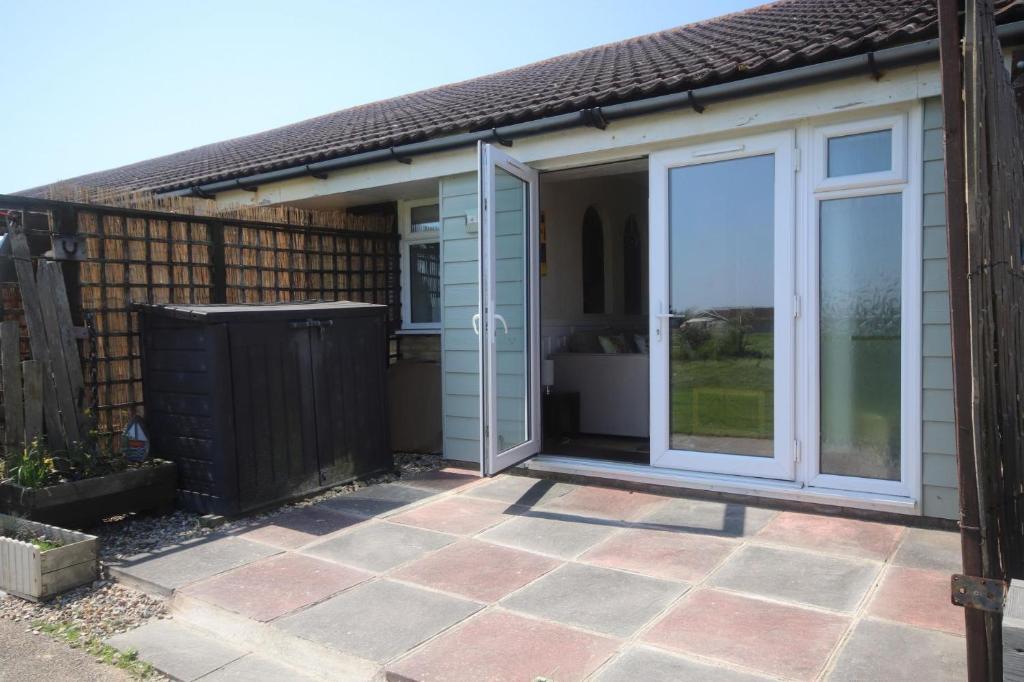 an extension to a garden room with a sliding glass door at 43C Medmerry Park 2 Bedroom Chalet in Earnley