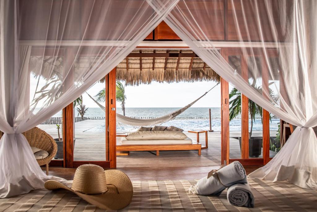 a bedroom with a hammock and a bed and the ocean at Kabana Hotel in Prea