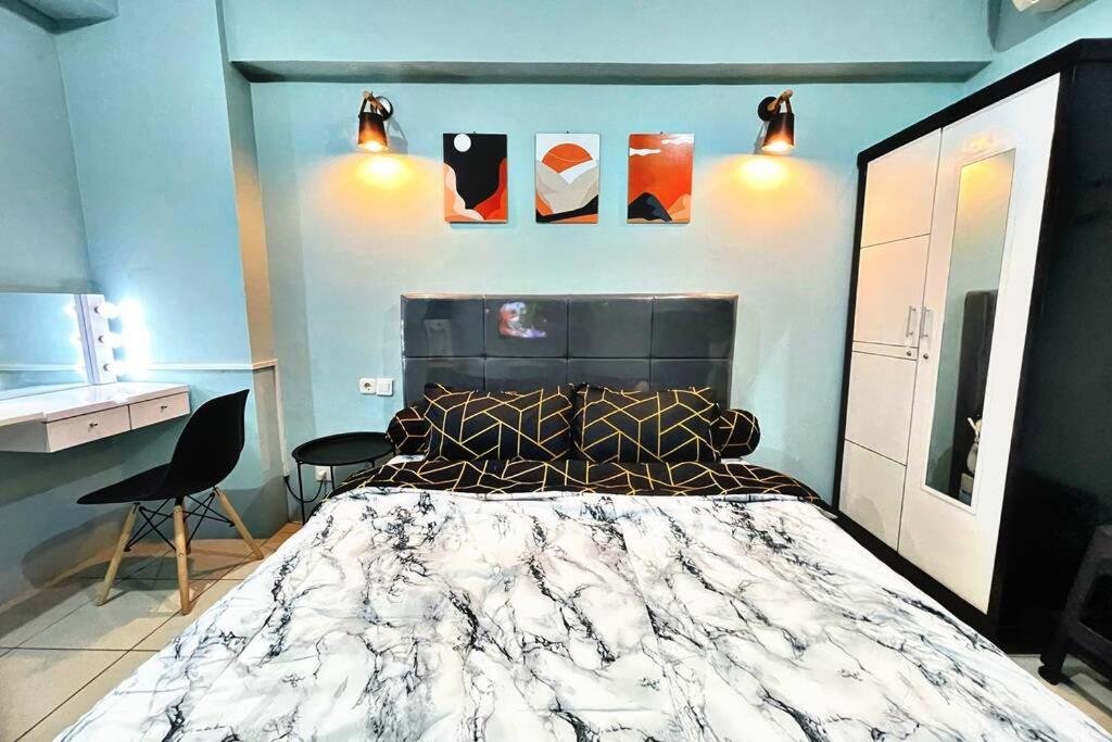 Scandinavian Homey Studio @Green Bay Pluit Apartment في جاكرتا: غرفة نوم بسرير كبير لحاف اسود وبيض