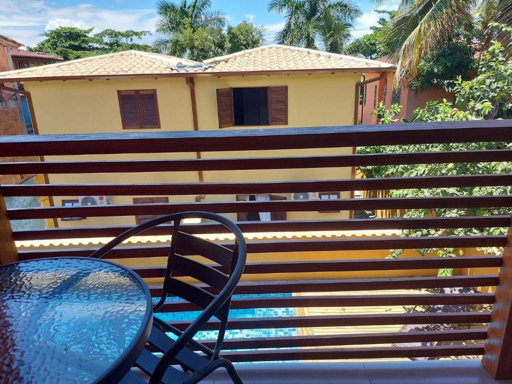 einen Tisch und einen Stuhl auf dem Balkon in der Unterkunft Cotia - Novo Flat com Piscina, 50mts da praia, churrasqueira privativa, ar con, wi-fi, netflix, garagem in Paraty