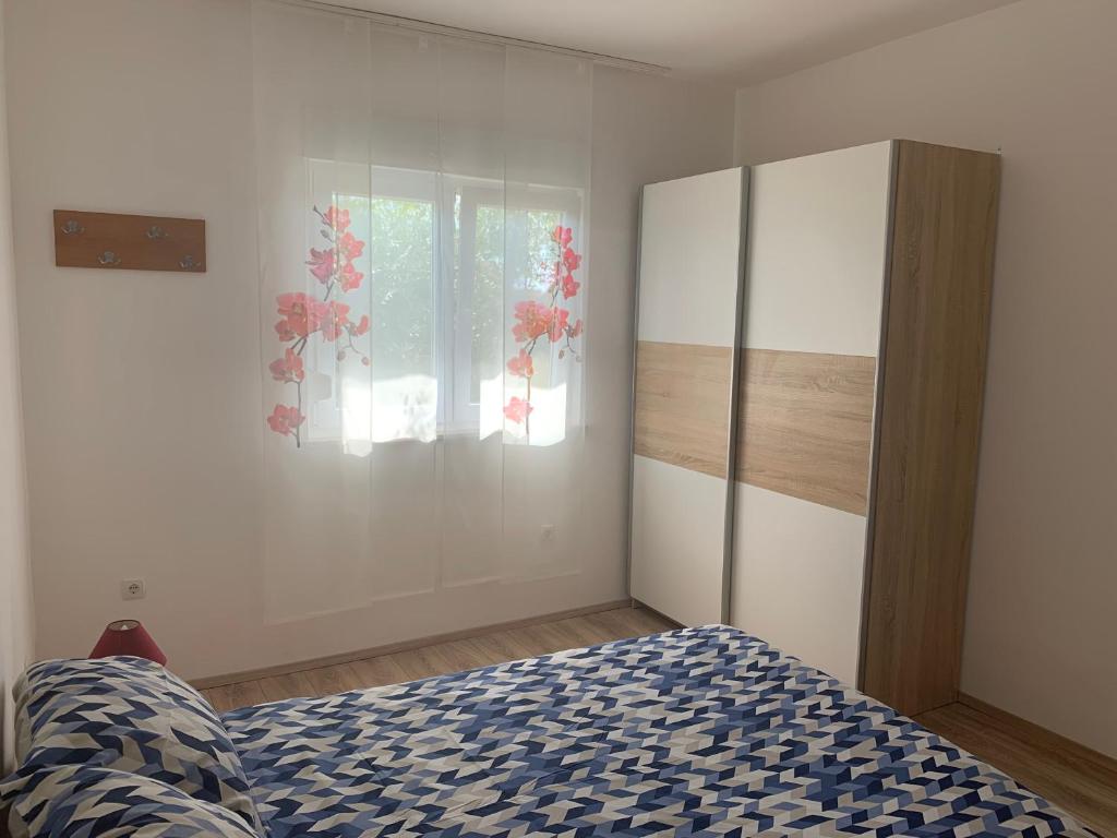 een slaapkamer met een bed, een dressoir en een raam bij Apartment Roni in Zadar