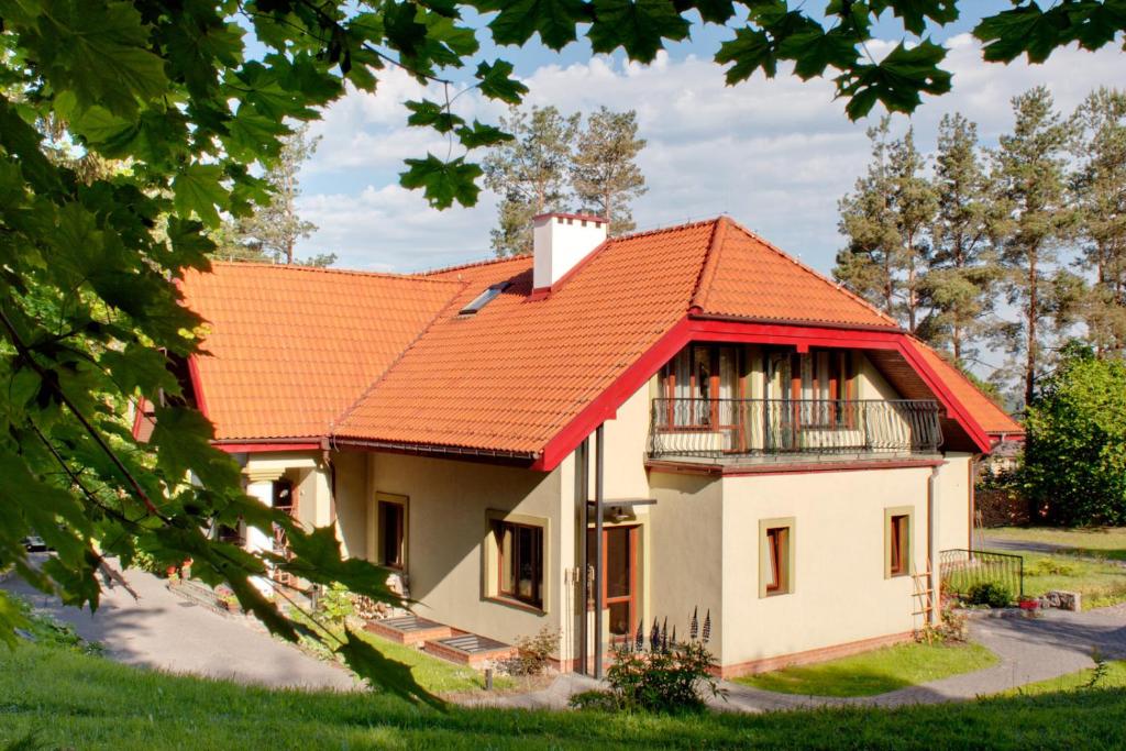 ein Haus mit orangefarbenem Dach in der Unterkunft Pensjonat Alicja in Kosewo