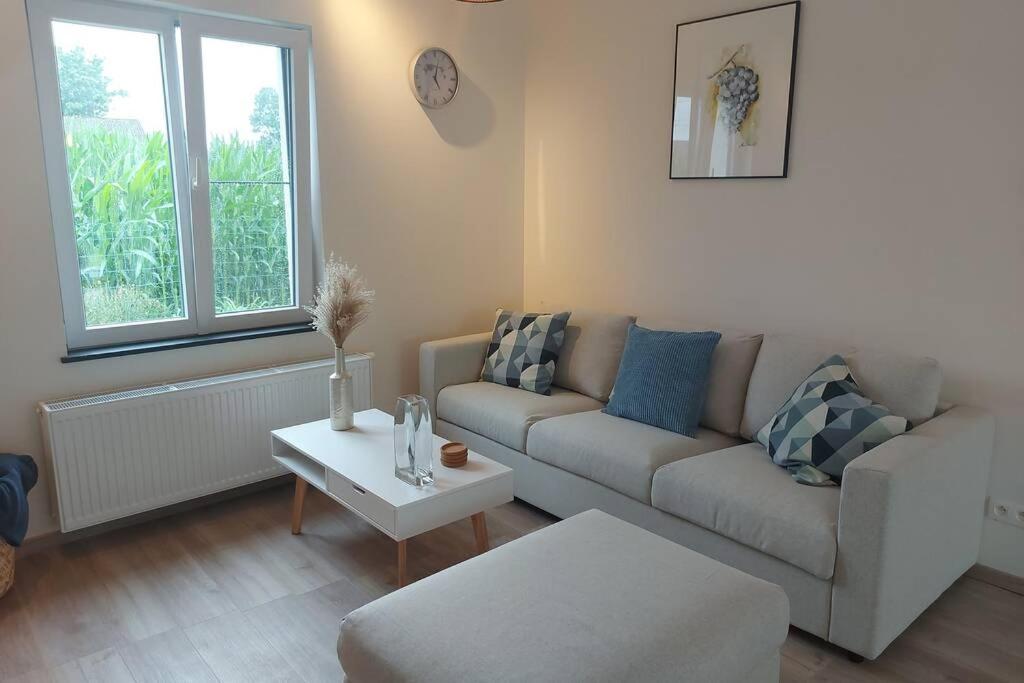 a living room with a couch and a table at Vakantiehuis Hagegoud: erop uit in het Hageland in Geetbets