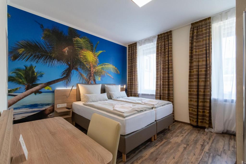 a bedroom with a bed and a palm tree mural at Hotel Mettlacher Hof in Mettlach