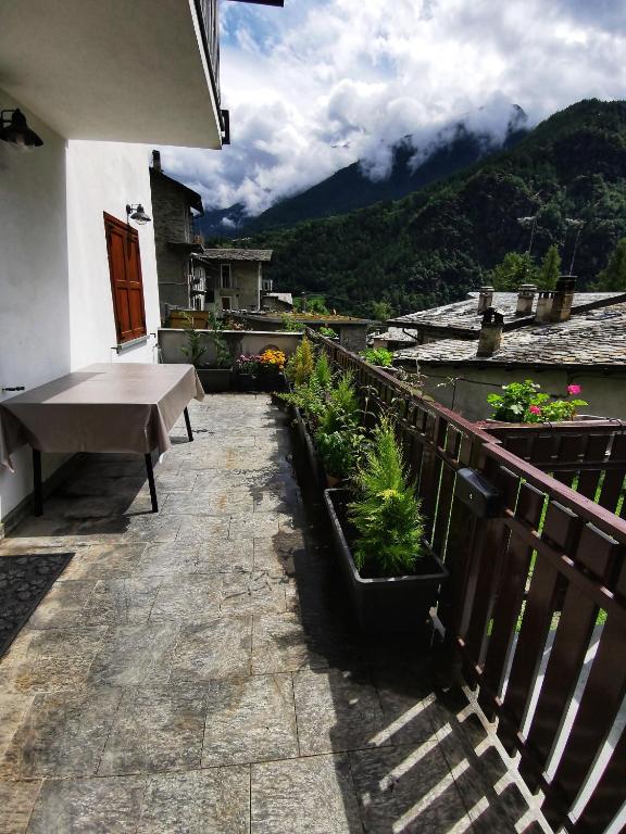 balkon ze stołem i roślinami na budynku w obiekcie Casa Lana w mieście Chiesa in Valmalenco
