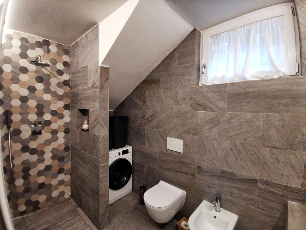 a bathroom with a toilet and a sink at Casa Lana in Chiesa in Valmalenco