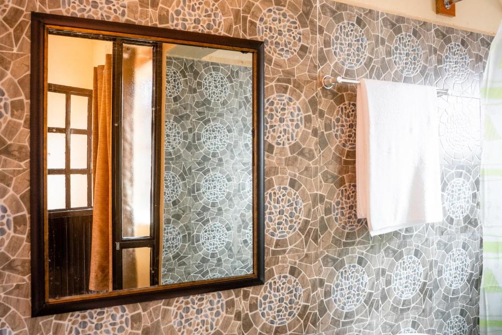 espejo en la pared del baño en Longonot Transit Hotel- Mai Mahiu, en Mai Mahiu